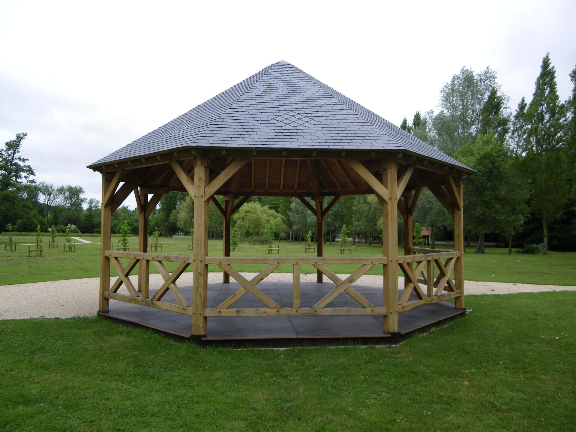 Petit pavillon avec toit en ardoise et charpente en bois.