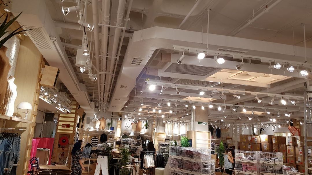 Una gran tienda de ropa con muchas luces en el techo.