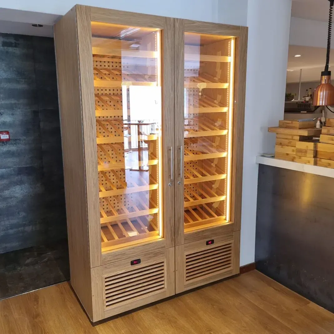 Un gran armario de madera con puertas de cristal lleno de botellas de vino.