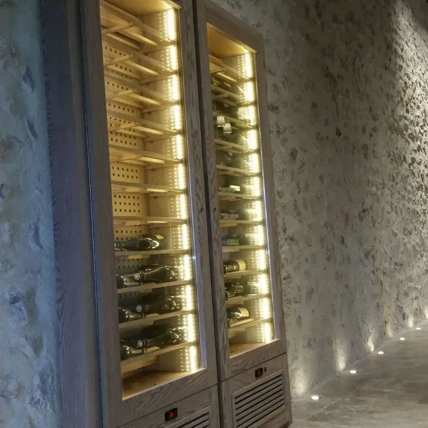 Un enfriador de vino lleno de muchas botellas de vino