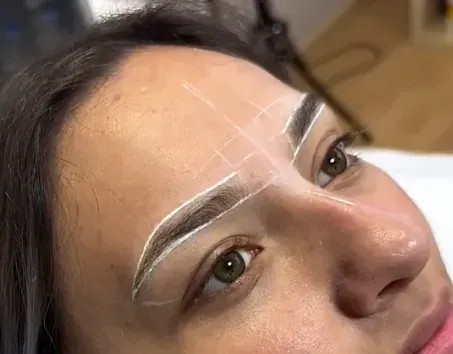 Un primer plano del rostro de una mujer con un dibujo de sus cejas.