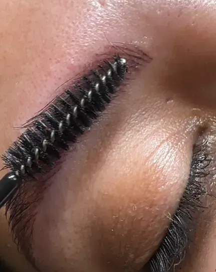 Un primer plano de las cejas de una mujer con un cepillo.