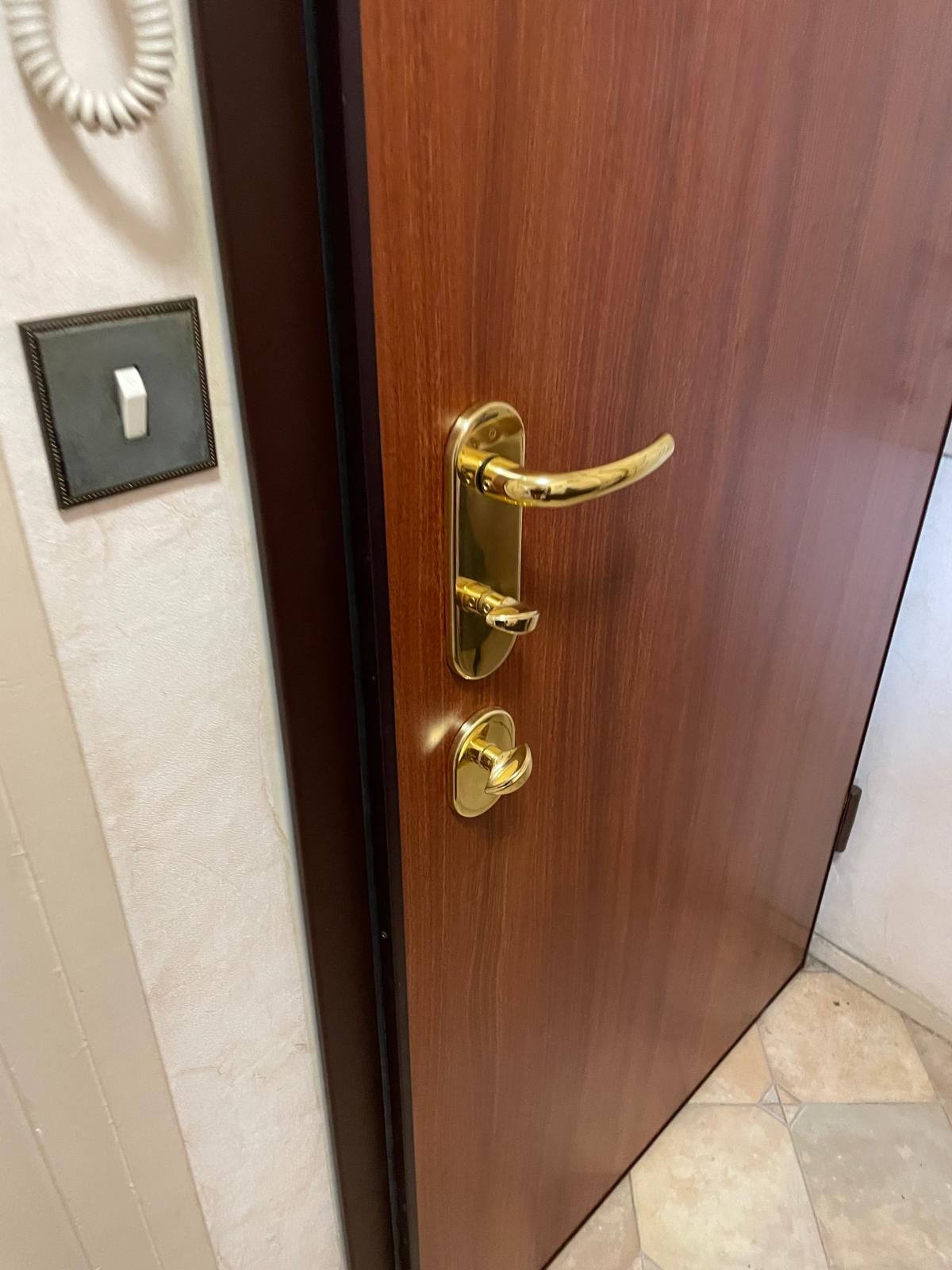 Porte blindée avec poignées dorées.