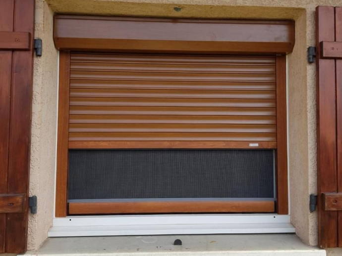 Fenêtre marron avec volet roulant partiellement fermé, moustiquaire et volets.