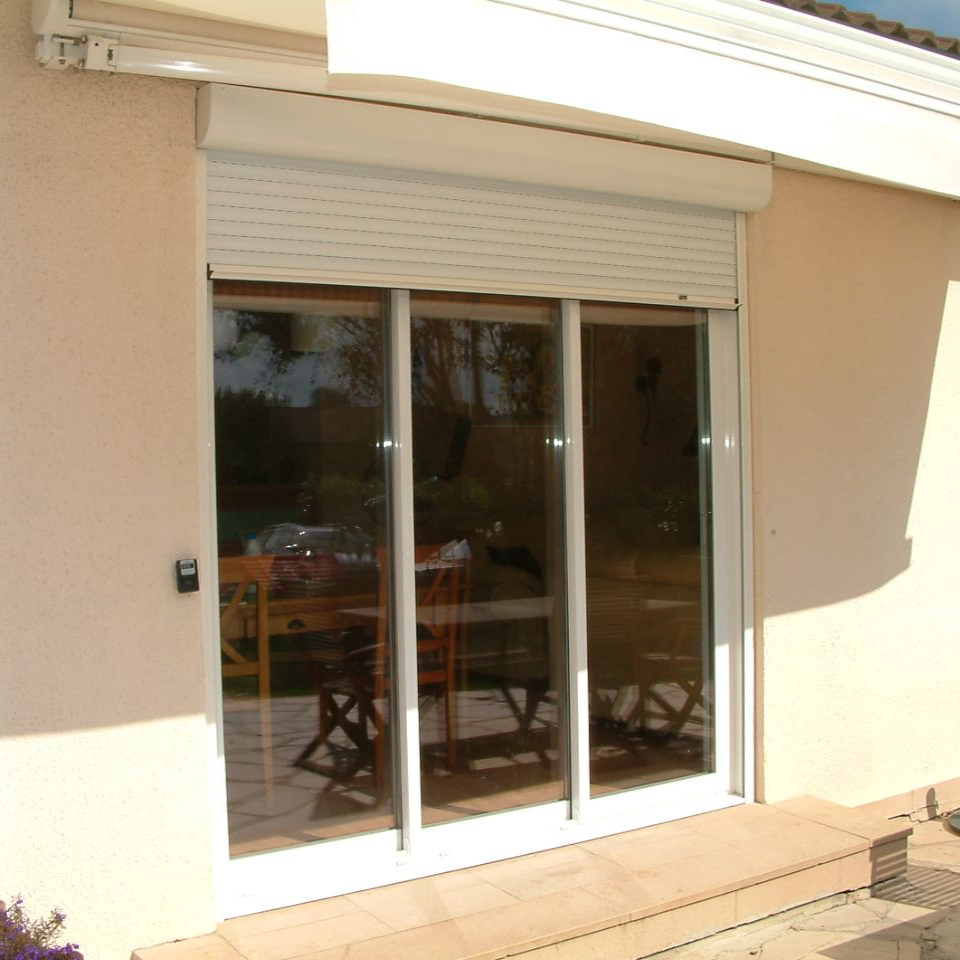 Portes coulissantes en verre avec un volet roulant blanc.