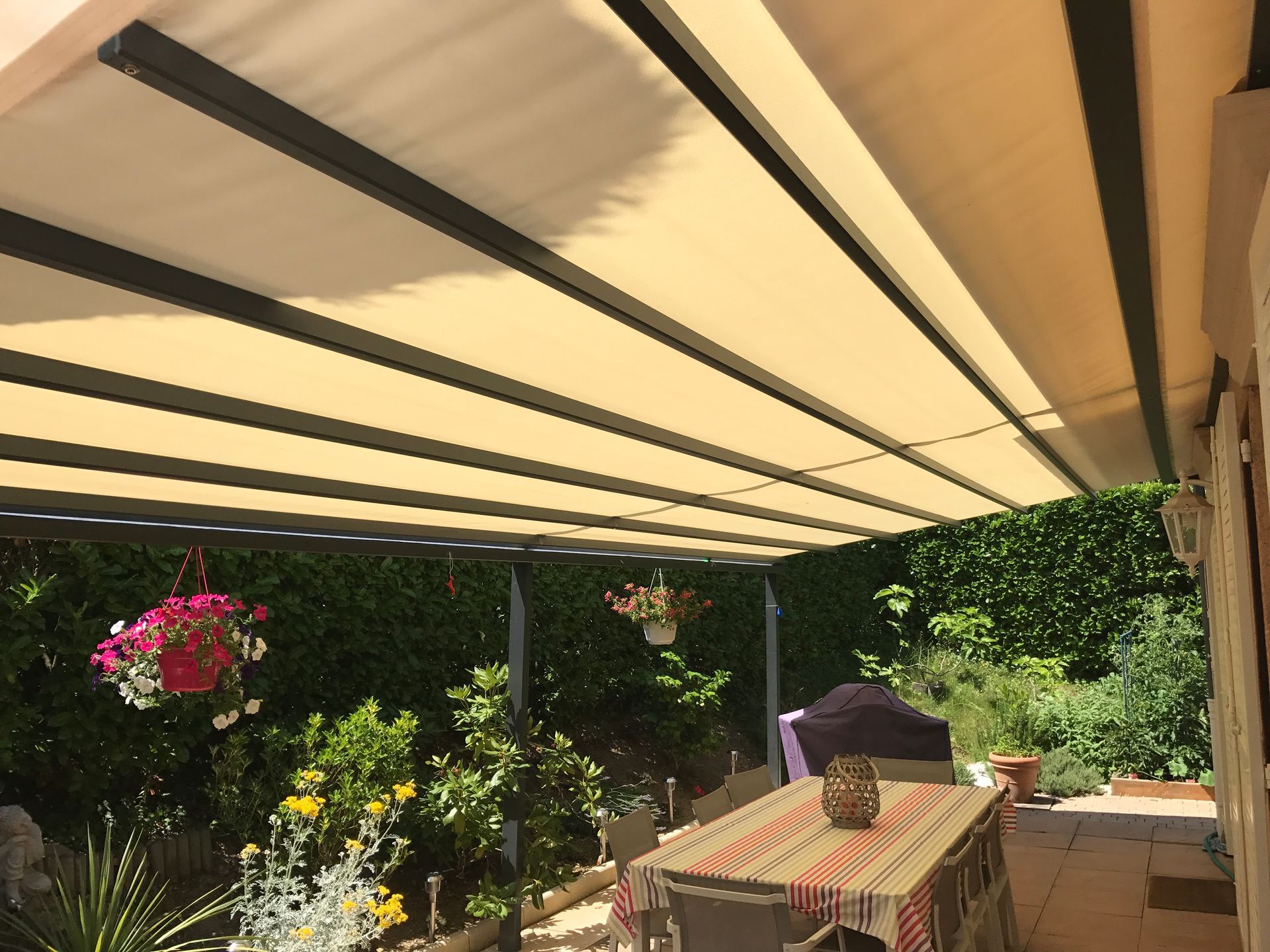 Une pergola rétractable recouvre une terrasse.