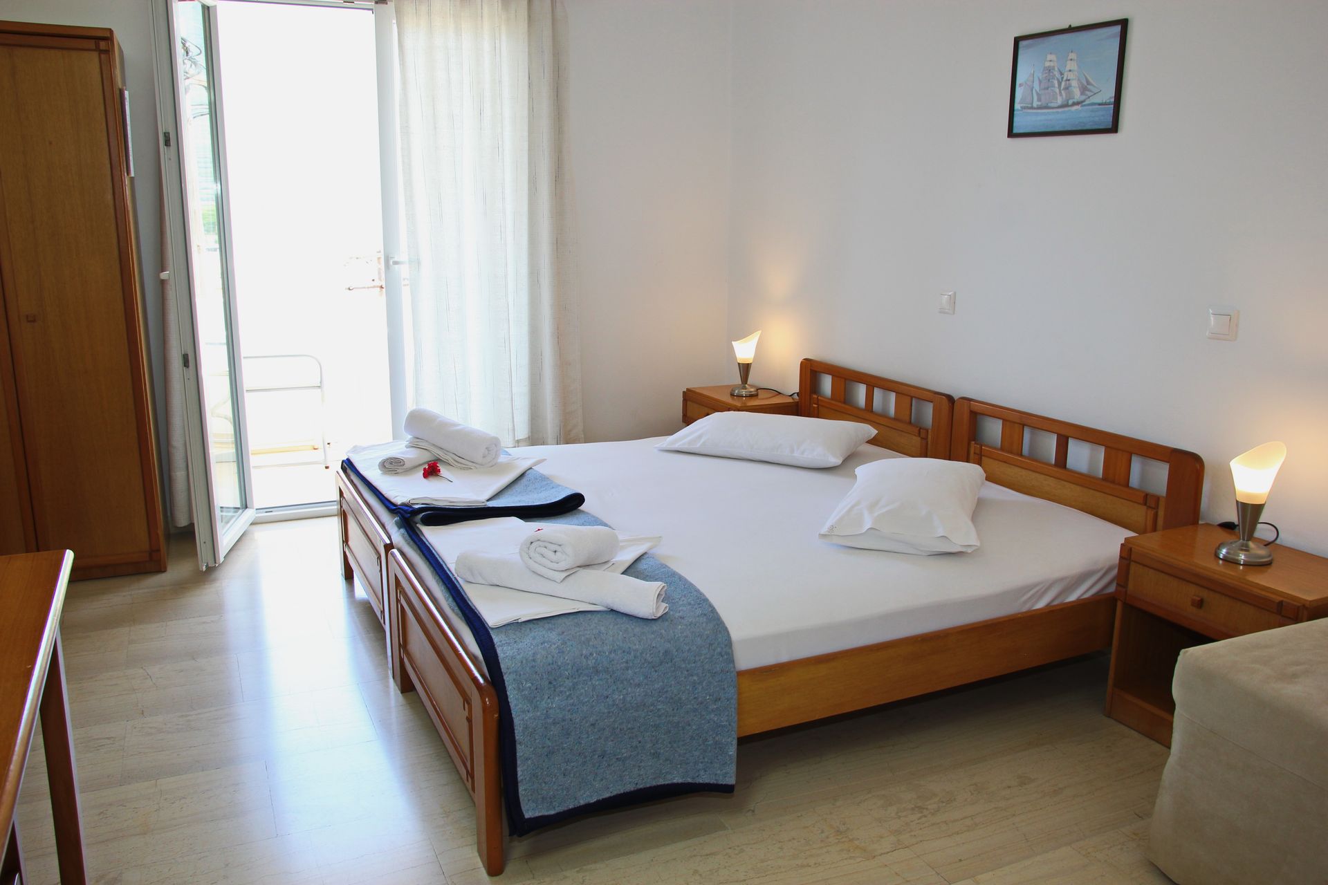 Υπνοδωμάτιο με διπλό κρεβάτι, κομοδίνα και ντουλάπα. Μια πόρτα οδηγεί σε μπαλκόνι.