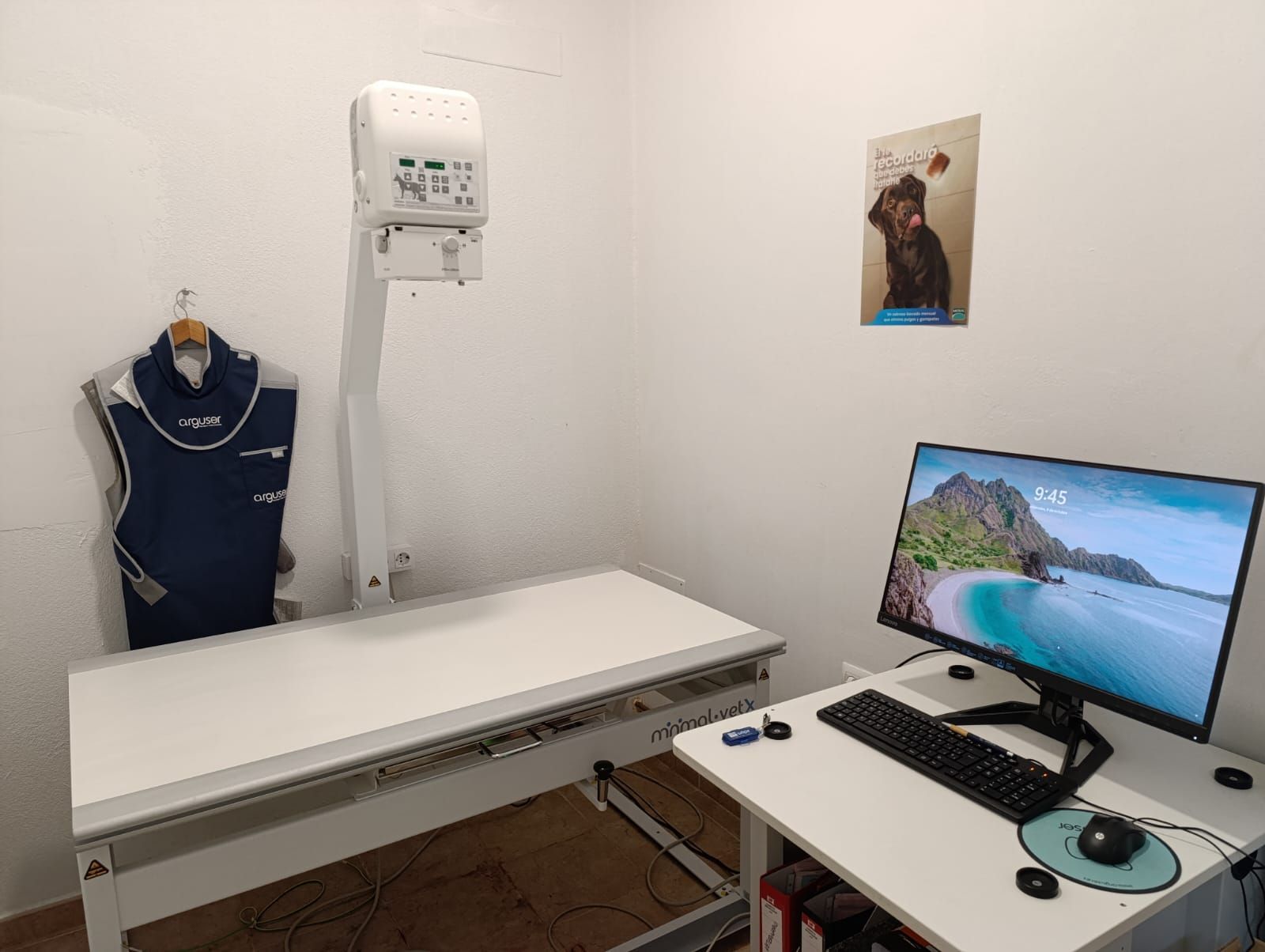 Una habitación con una mesa, una computadora y una máquina de rayos X.