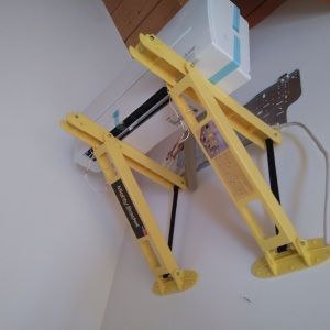 Ein gelber Aufbau für eine Klimaanlage an einer weißen Wand. Lierheimer Kältetechnik