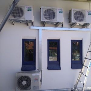 An der Seite eines Gebäudes befinden sich drei Klimaanlagen. Lierheimer Kältetechnik