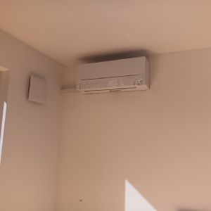 In einem Raum hängt eine weiße Klimaanlage an der Decke. Lierheimer Kältetechnik