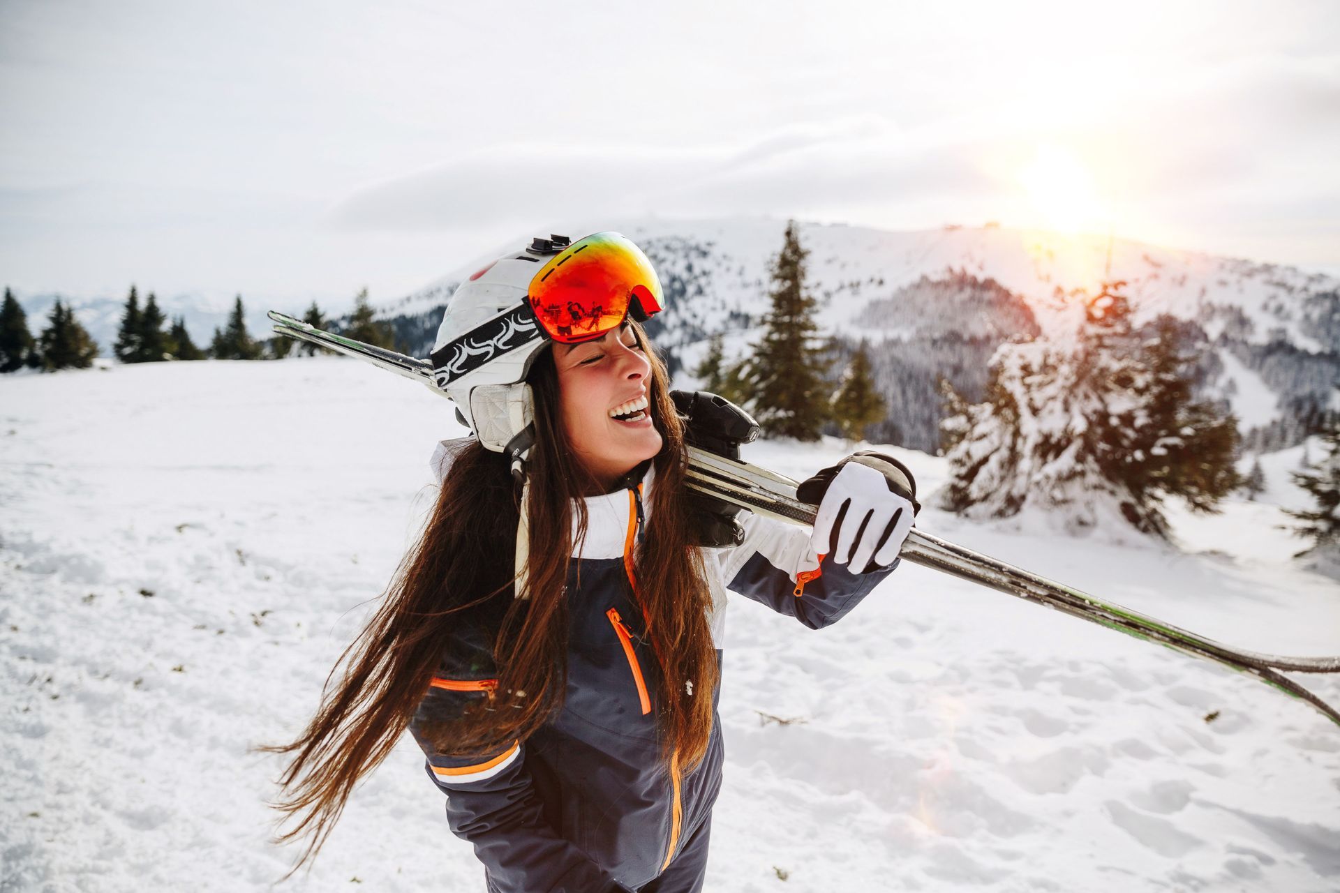Jeune femme souriante, les skis sur l'épaule