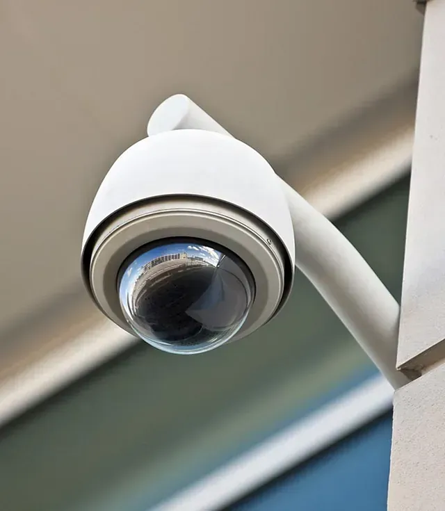Una cámara de seguridad está montada en el costado de un edificio.