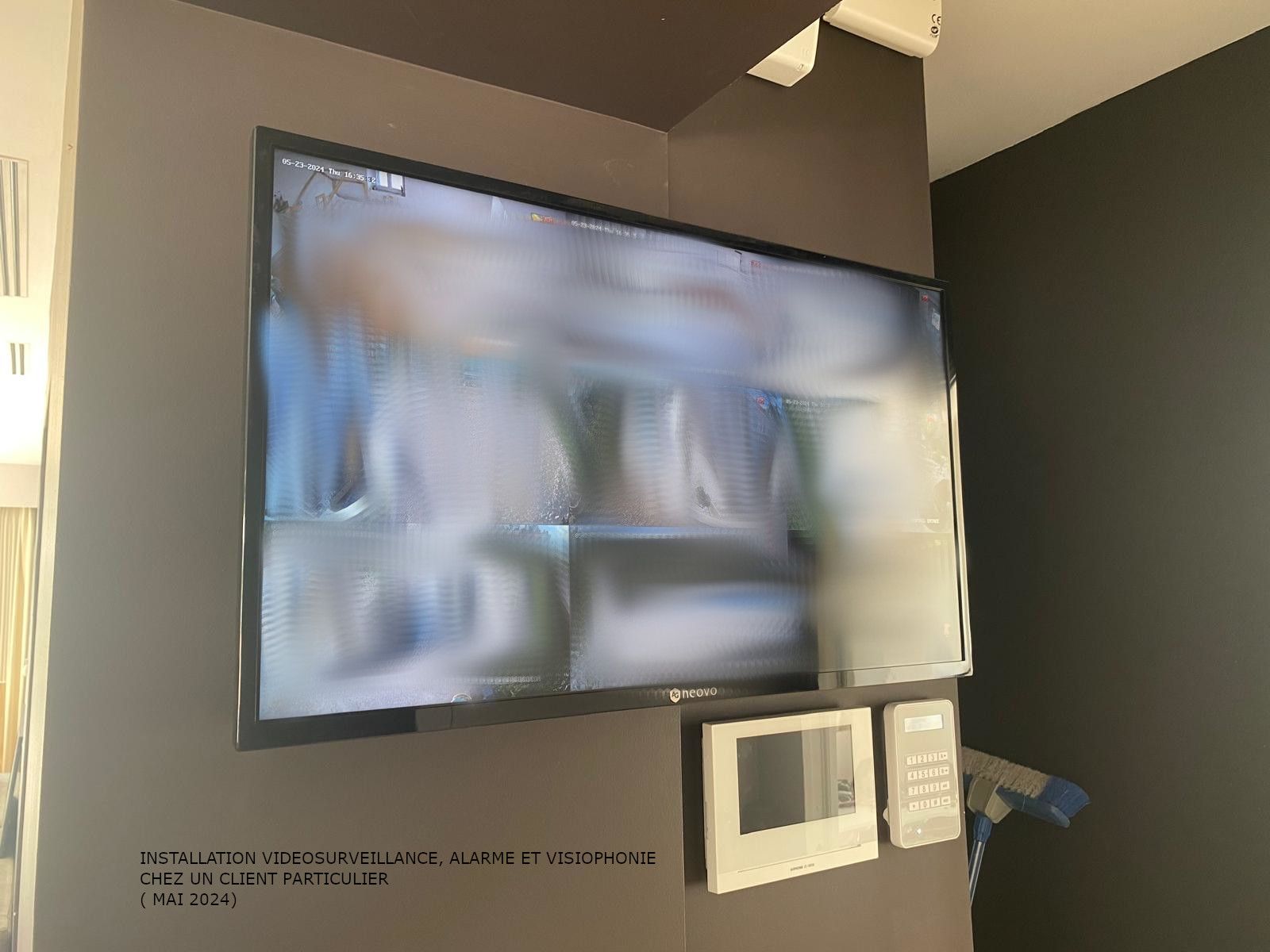 Écran de télévision mural au-dessus d'un comptoir avec deux petits présentoirs et un distributeur bleu dans une pièce