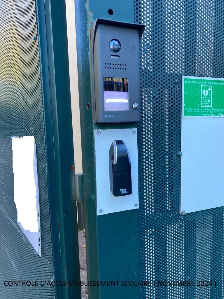 Interphone d'immeuble et panneau d'entrée sans clé sur un portail métallique vert