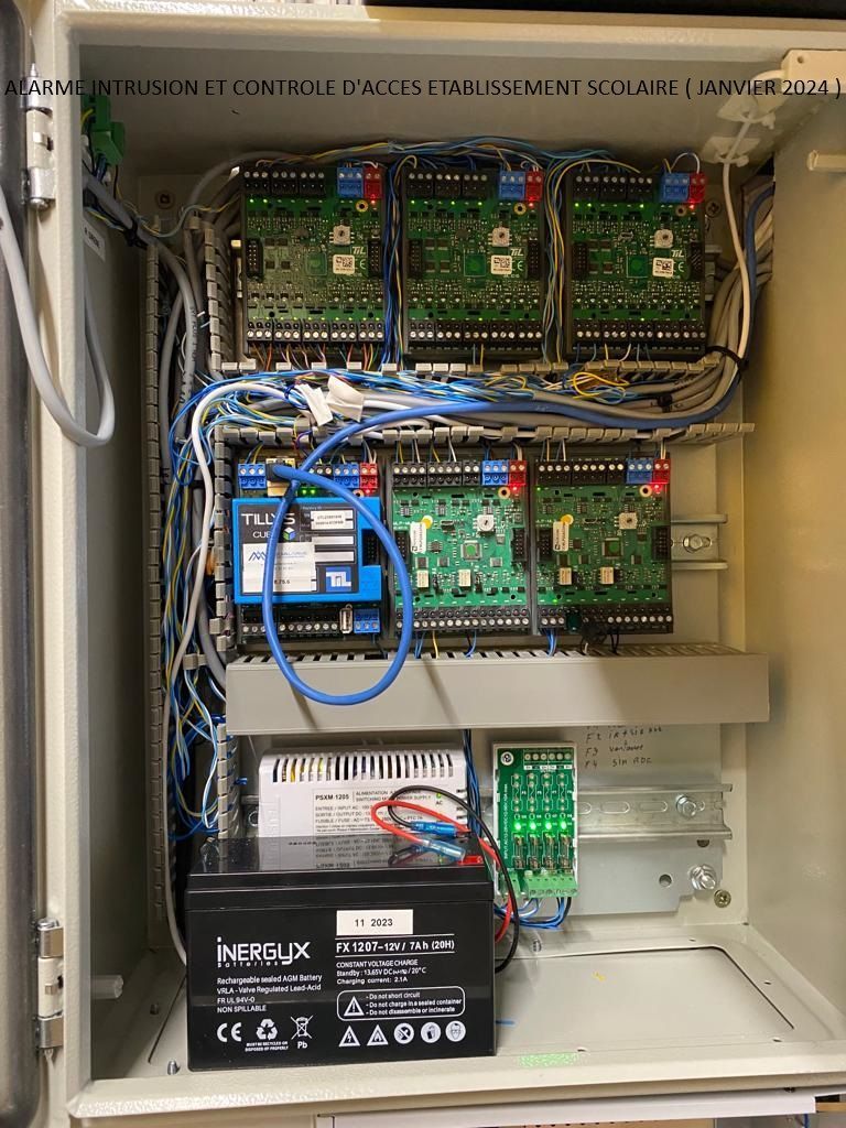 Armoire électrique ouverte contenant des cartes de circuits imprimés, des câblages, des relais et une batterie.