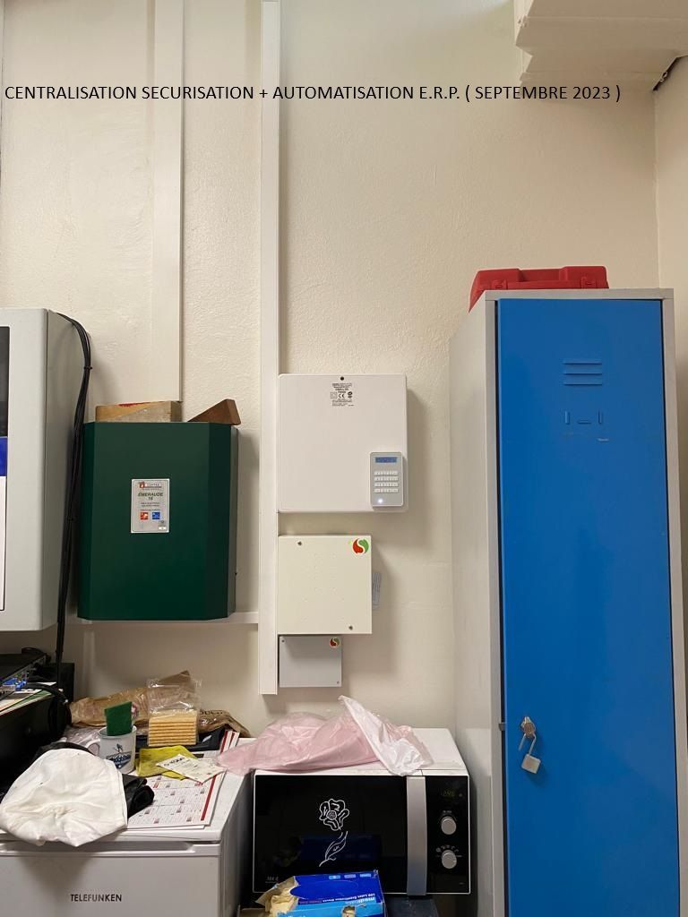 Mur avec boîtes et casiers fixés au mur dans une buanderie, avec une table et un évier encombrés en dessous.