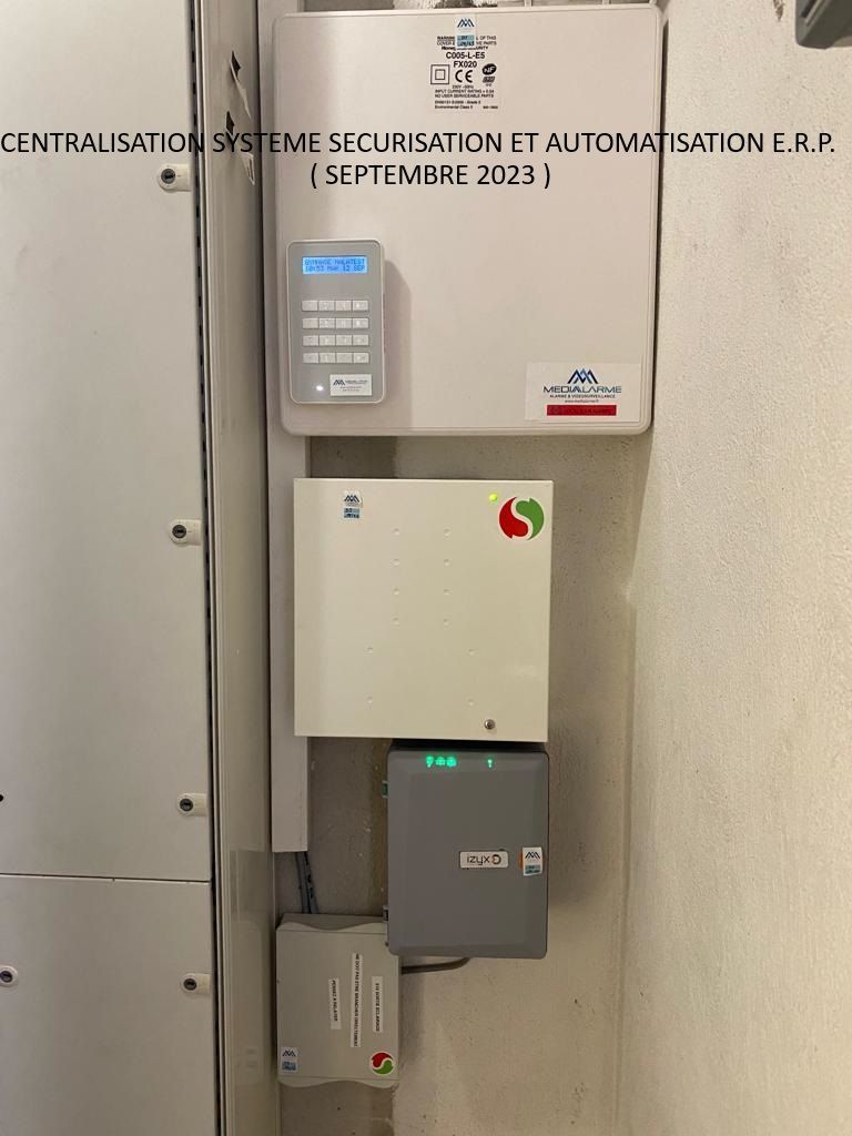 Système de contrôle d'accès mural avec clavier, boîtiers de commande et câblage sur un mur beige