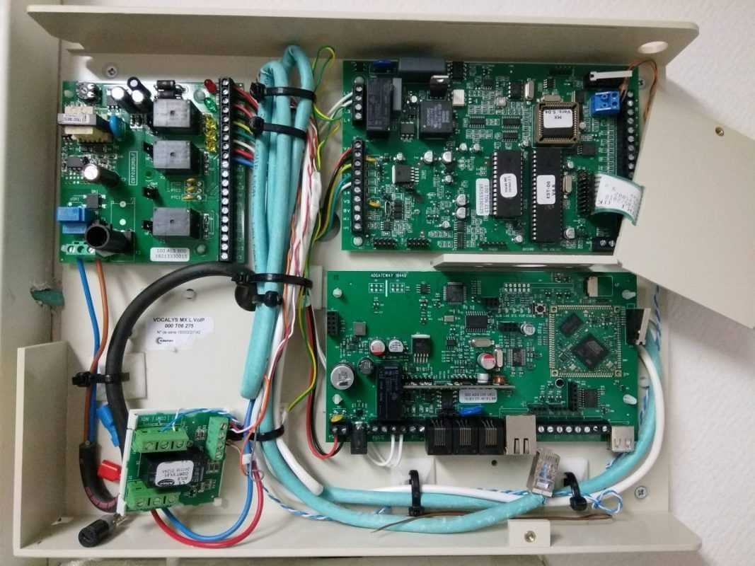 Boîtier de commande électronique ouvert contenant des cartes de circuits imprimés, des câbles et des connecteurs à l'intérieur d'un boîtier beige