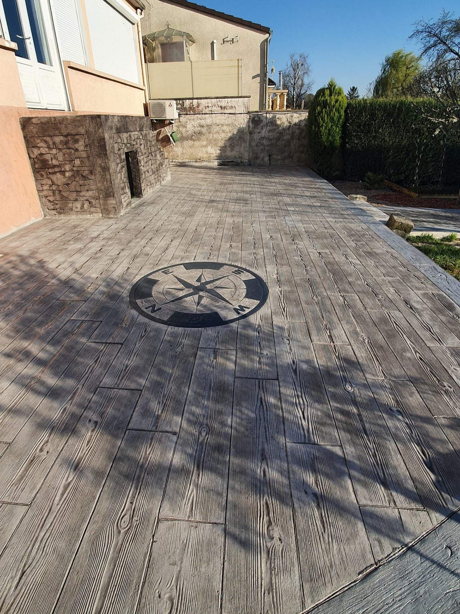 Une terrasse en béton imprimé beige avec une rose des vents.
