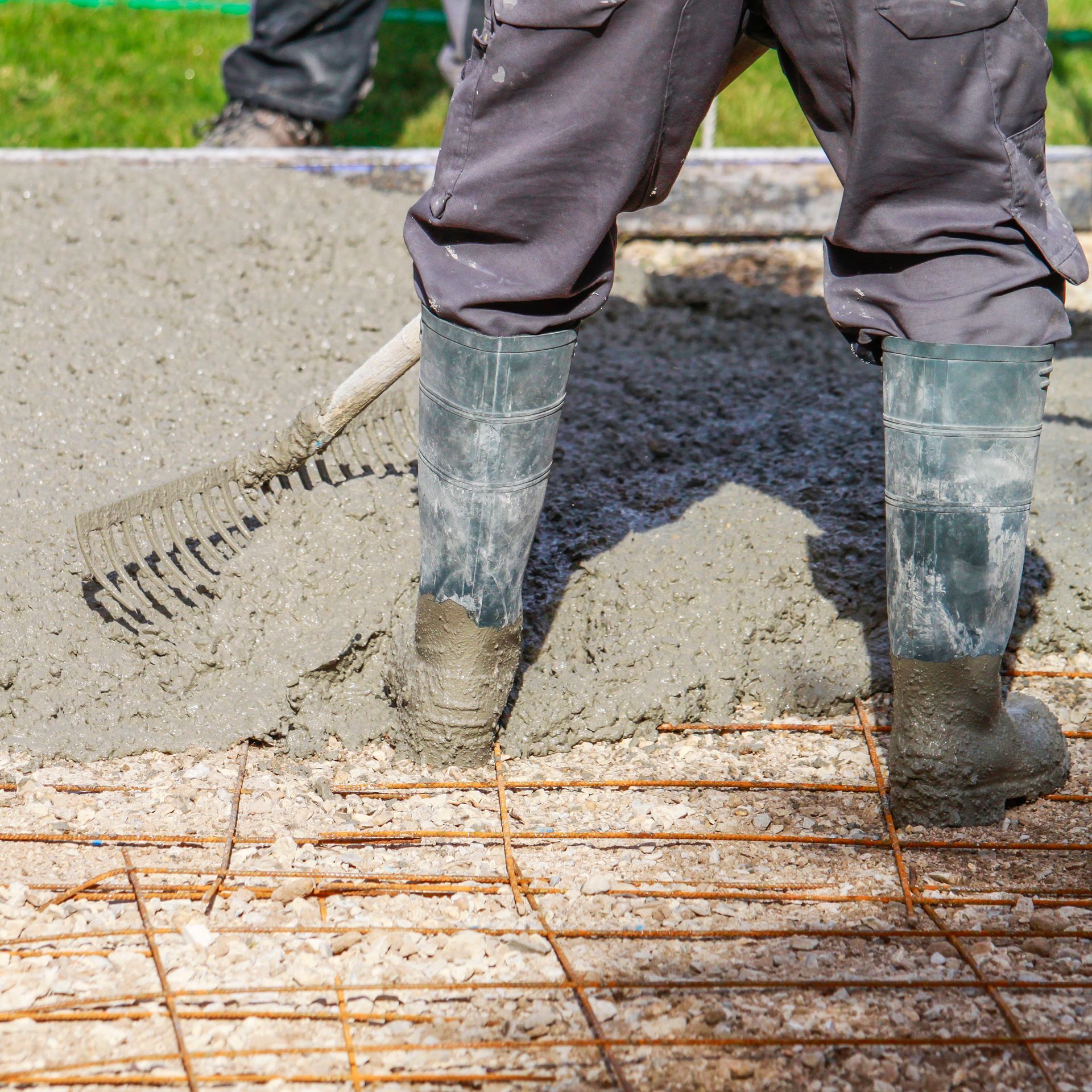 Un homme nivelle du béton.