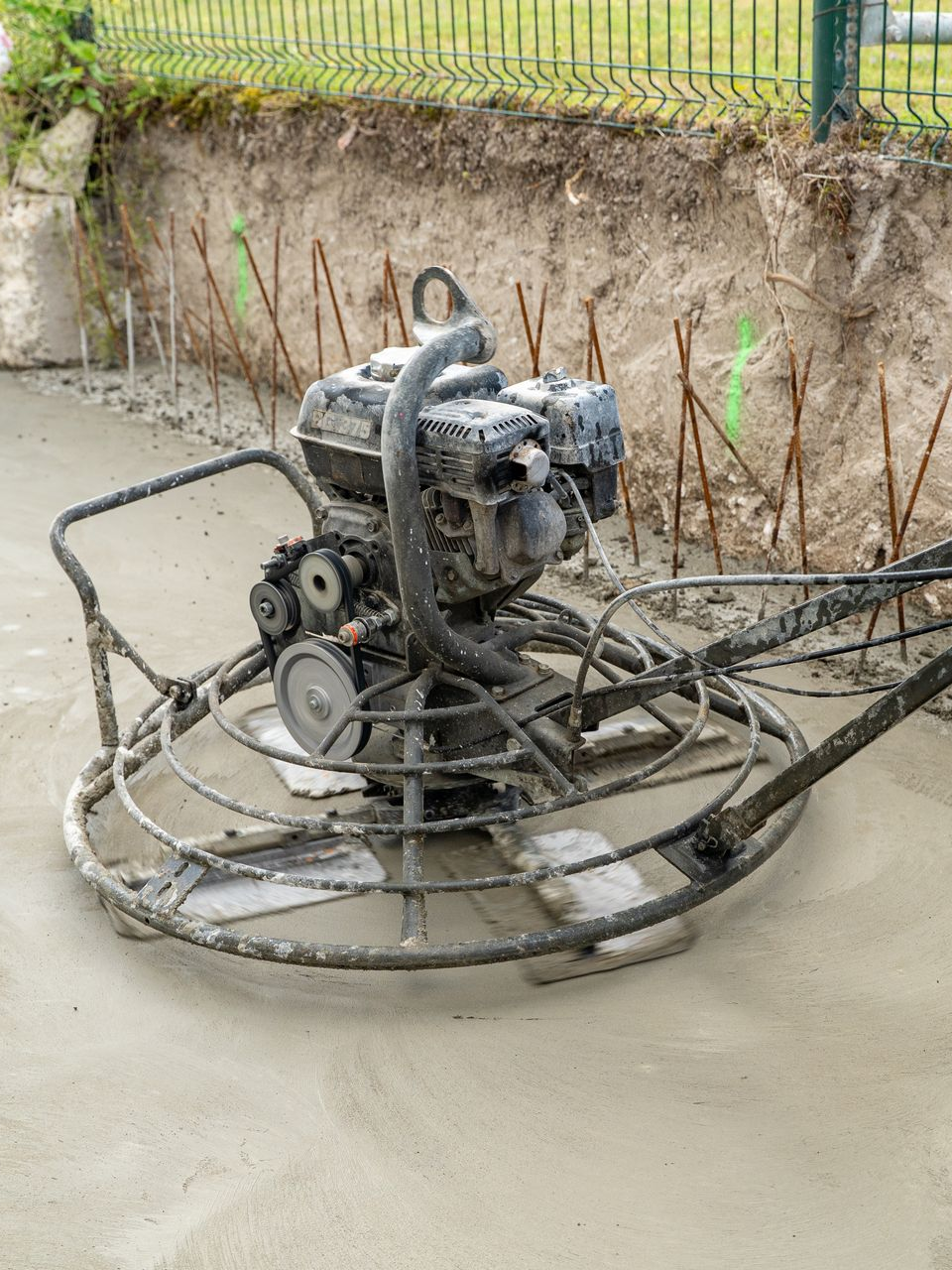 Un homme passe l'hélicoptère à béton sur une terrasse en construction.