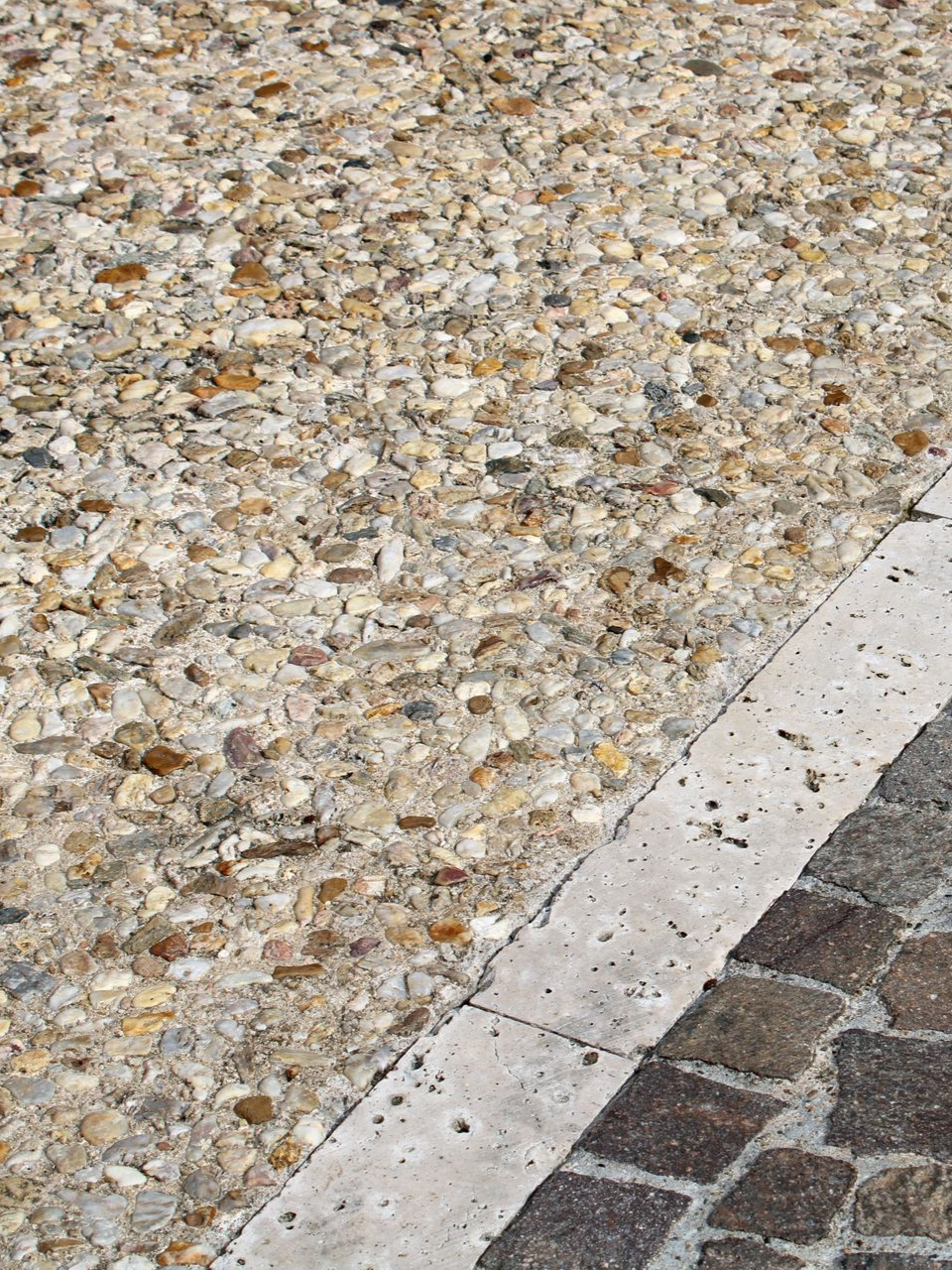 Du béton désactivé beige et cailloux intégrés visibles.