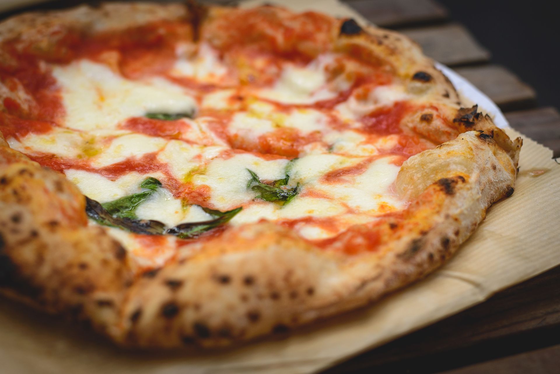 Eine Pizza mit Schinken und Käse auf weissem Hintergrund.