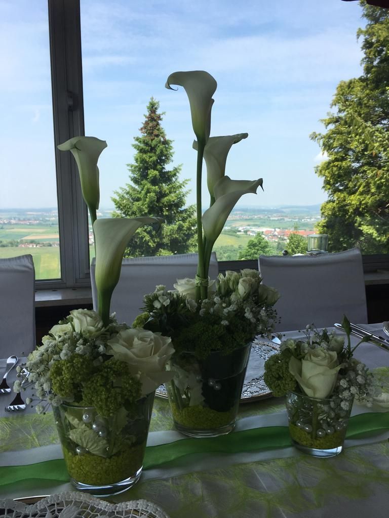 Drei weiße Blumengestecke als Tischdeko