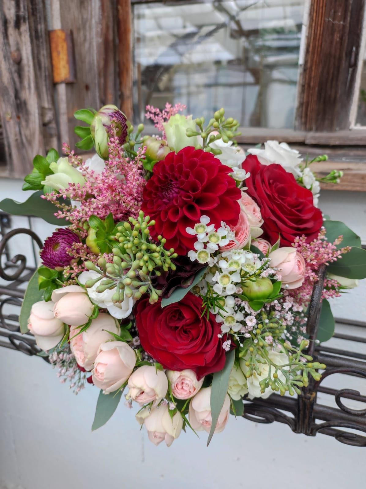 Brautstrauß mit cremefarbenen, lachsfarbenen und roten Rosen