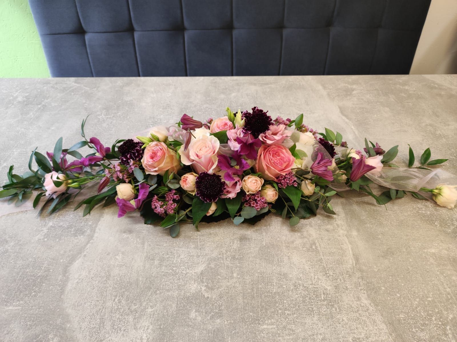 Tisch mit Blumendekoration in den Farben lila und Pink