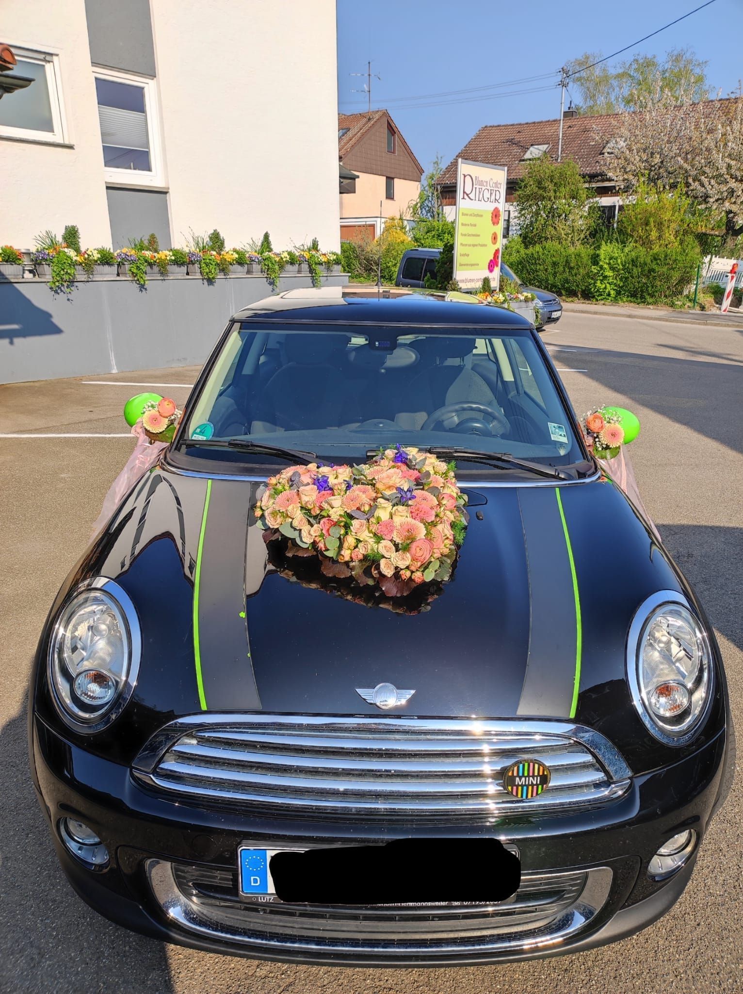 Auto mit Herzblumengesteck und Blumen an den Seitenspiegeln