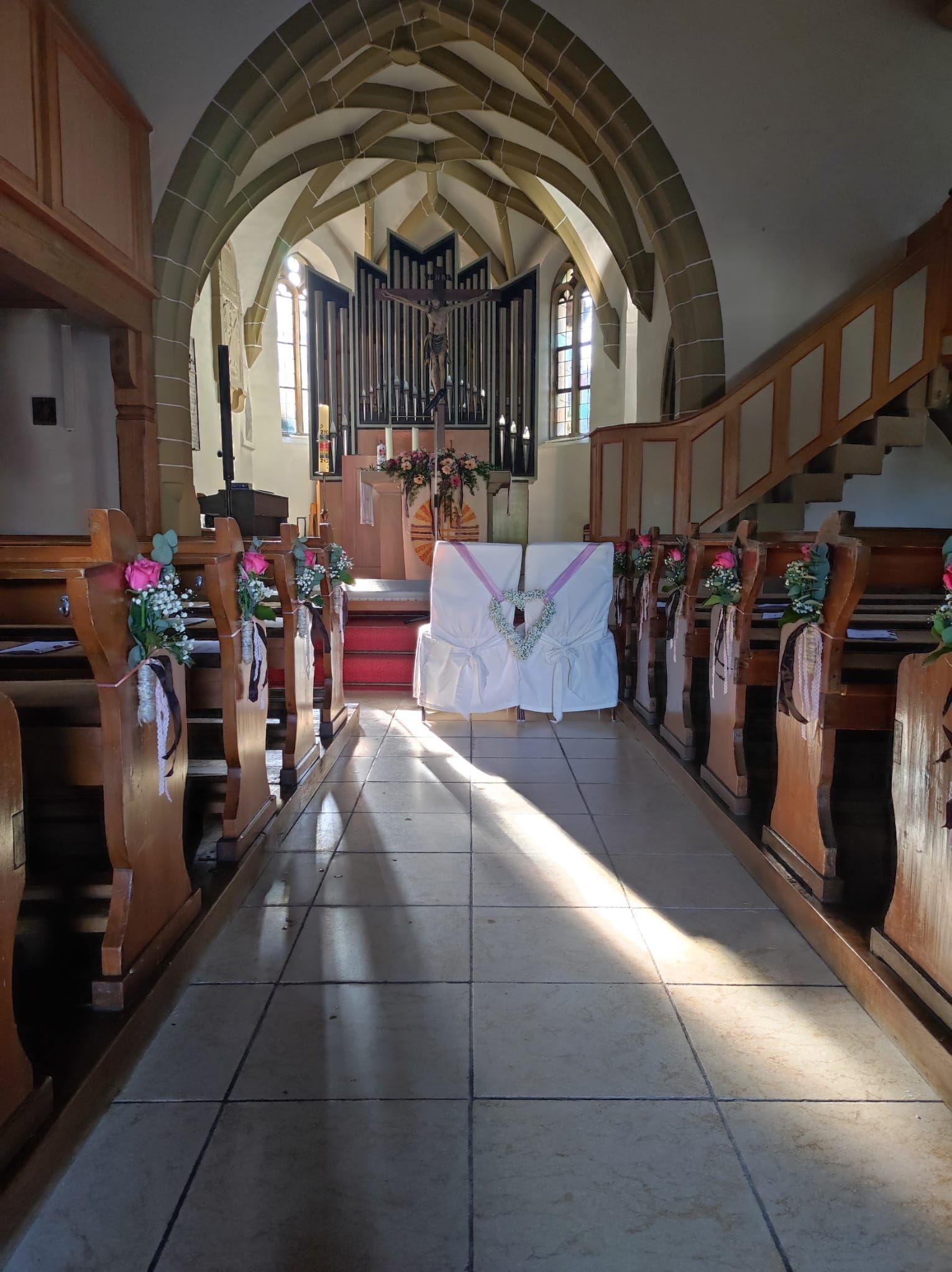 Kirchenkapelle mit Blumen, Deko an den Bänken und an den Sitzen des Brautpaares