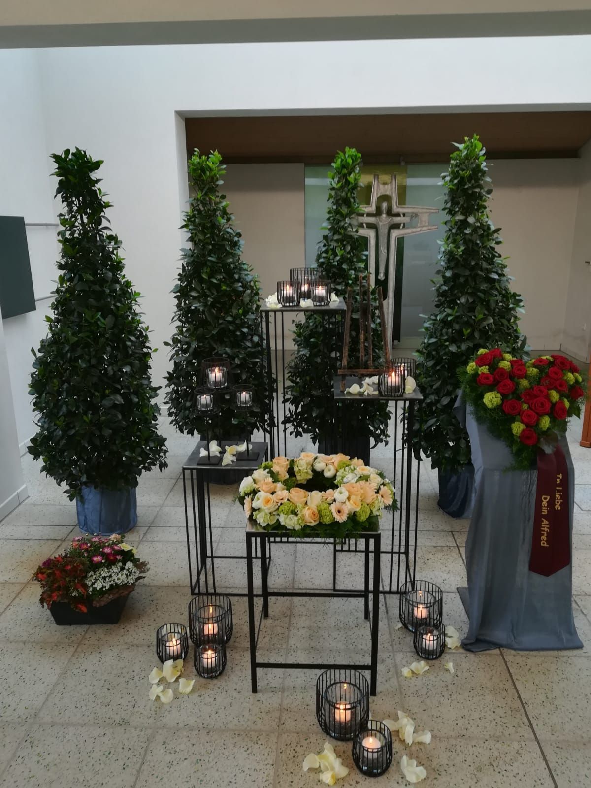 Trauerkranz mit gelben Gerbera und Sonnenblumen und Herzblumengesteck in den Farben Rot und Grün