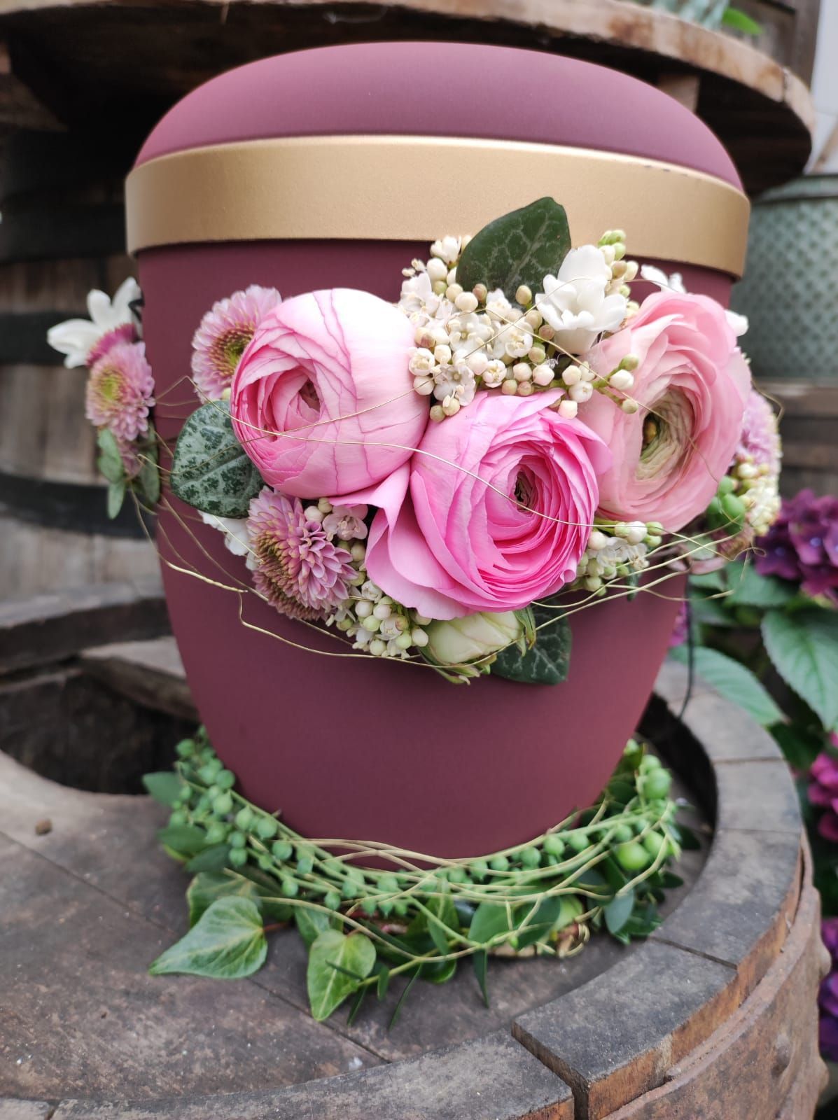 Urne mit Blumen verziert in den Farben Rosa und Pink