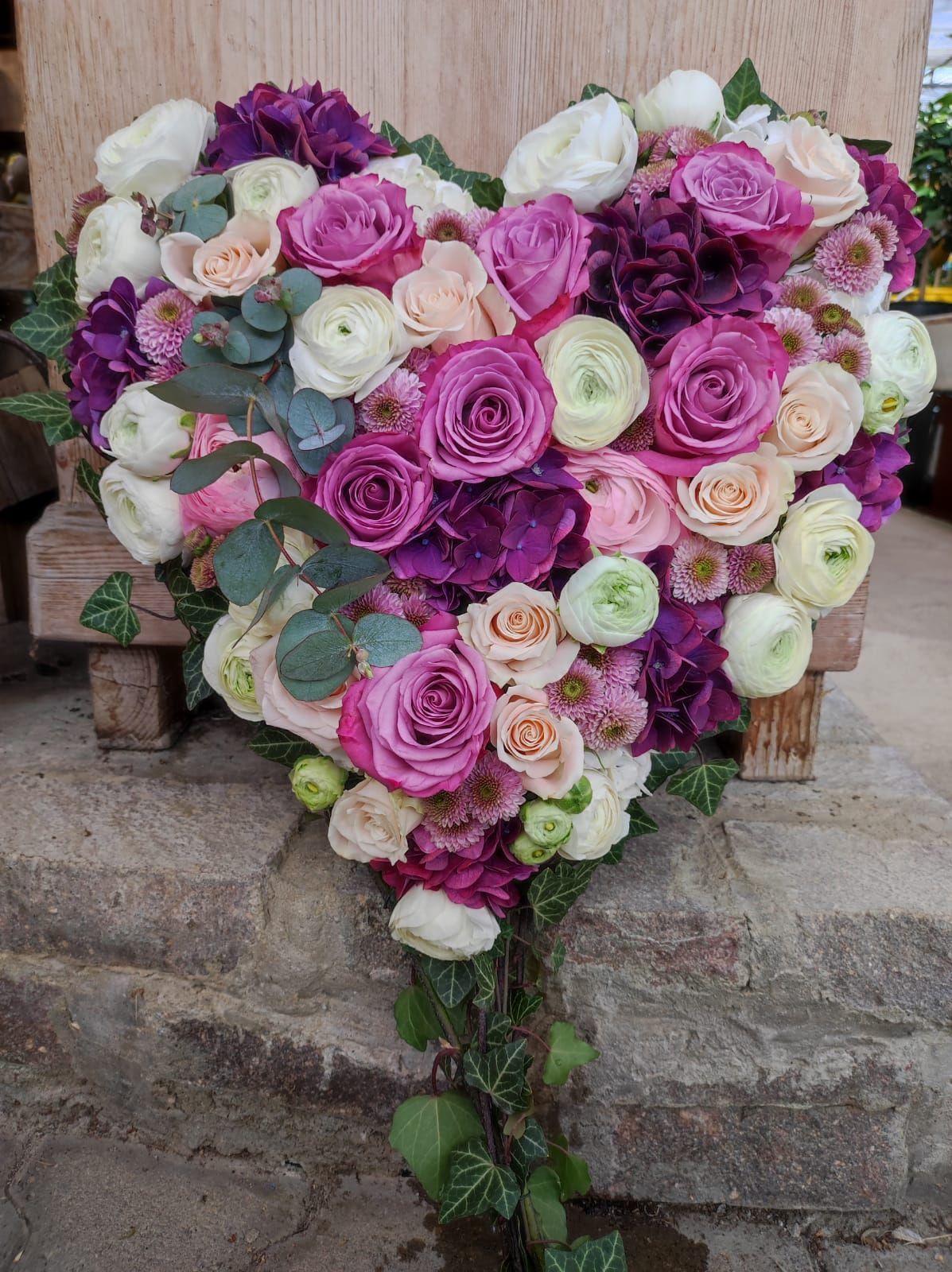 Blumengesteck in Herzform in den Farben Pink, Lila und Weiß
