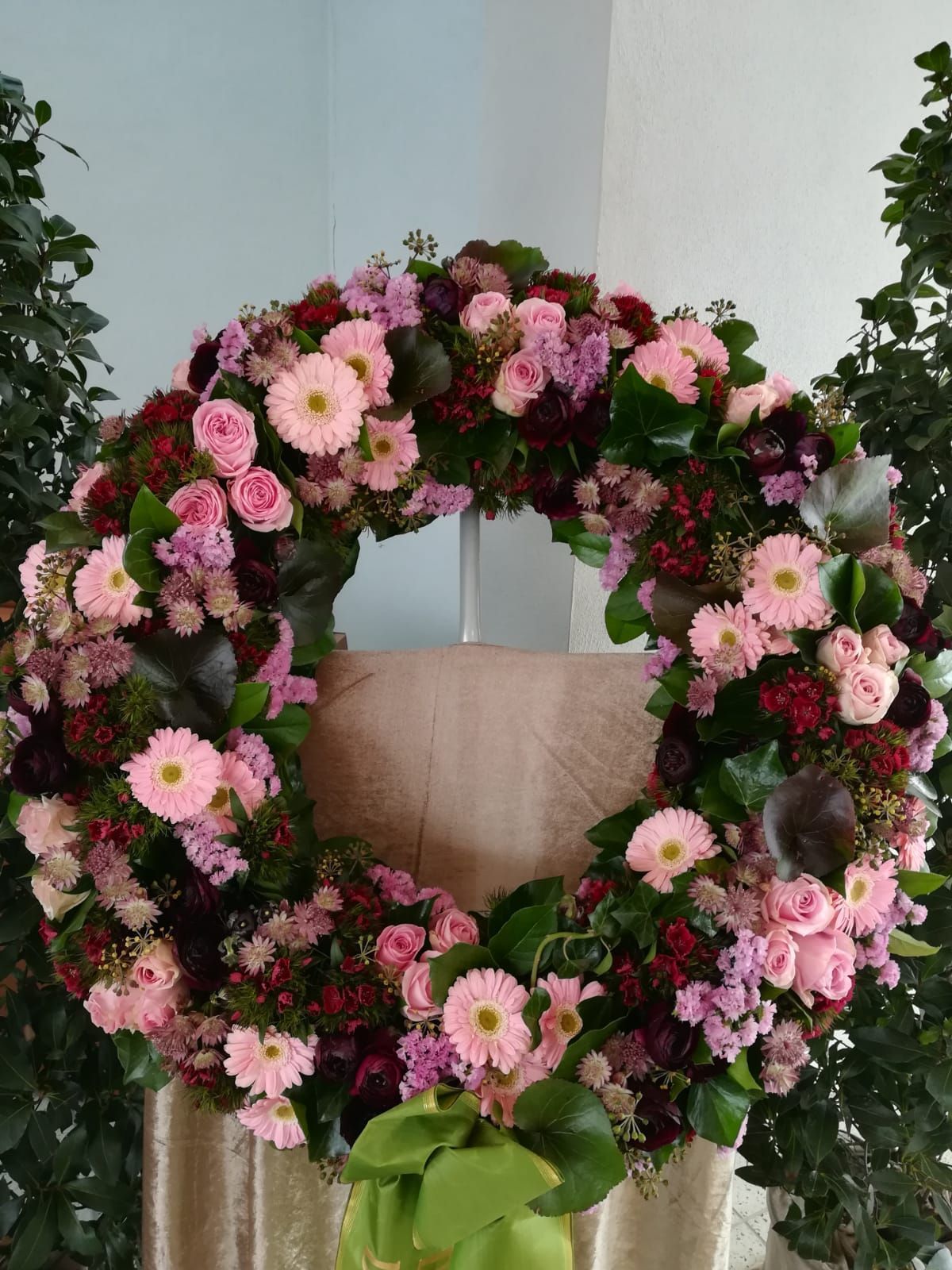 Trauerkranz mit Gerbera und Rosen und den Farben Rot, Rosa und Pink