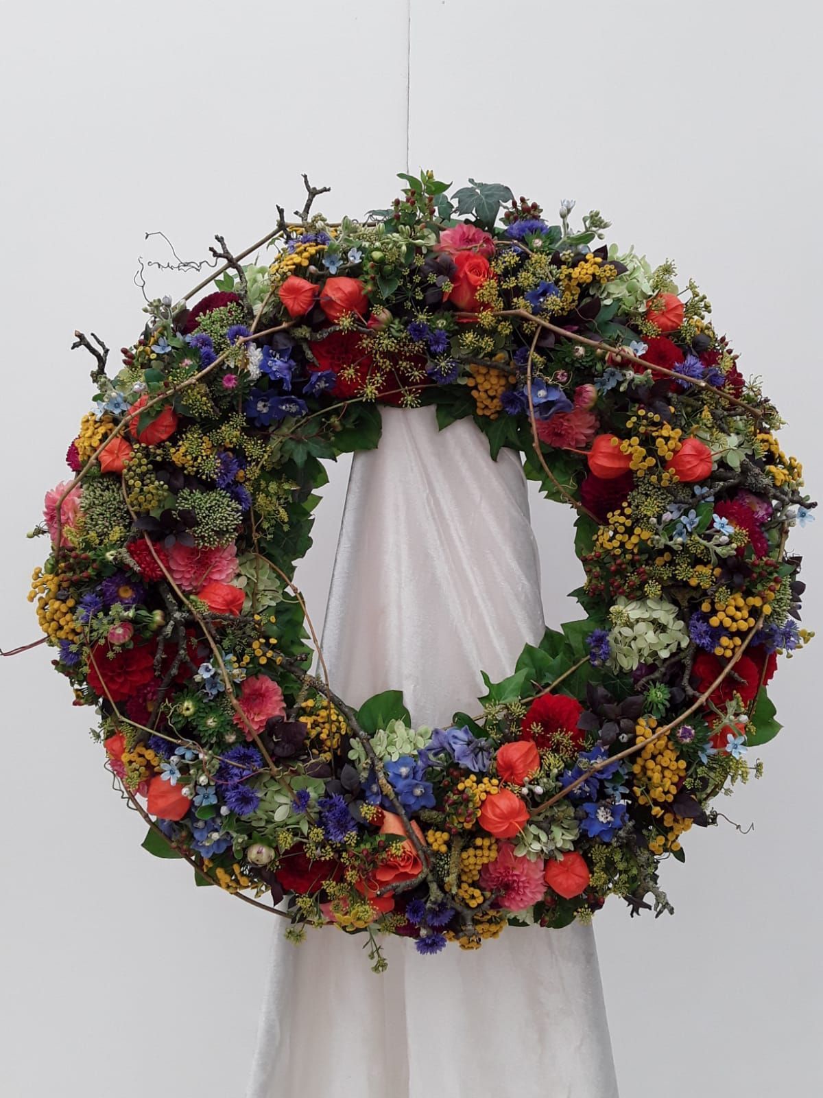 Trauerkranz in den Farben Blau, Rot und Gelb