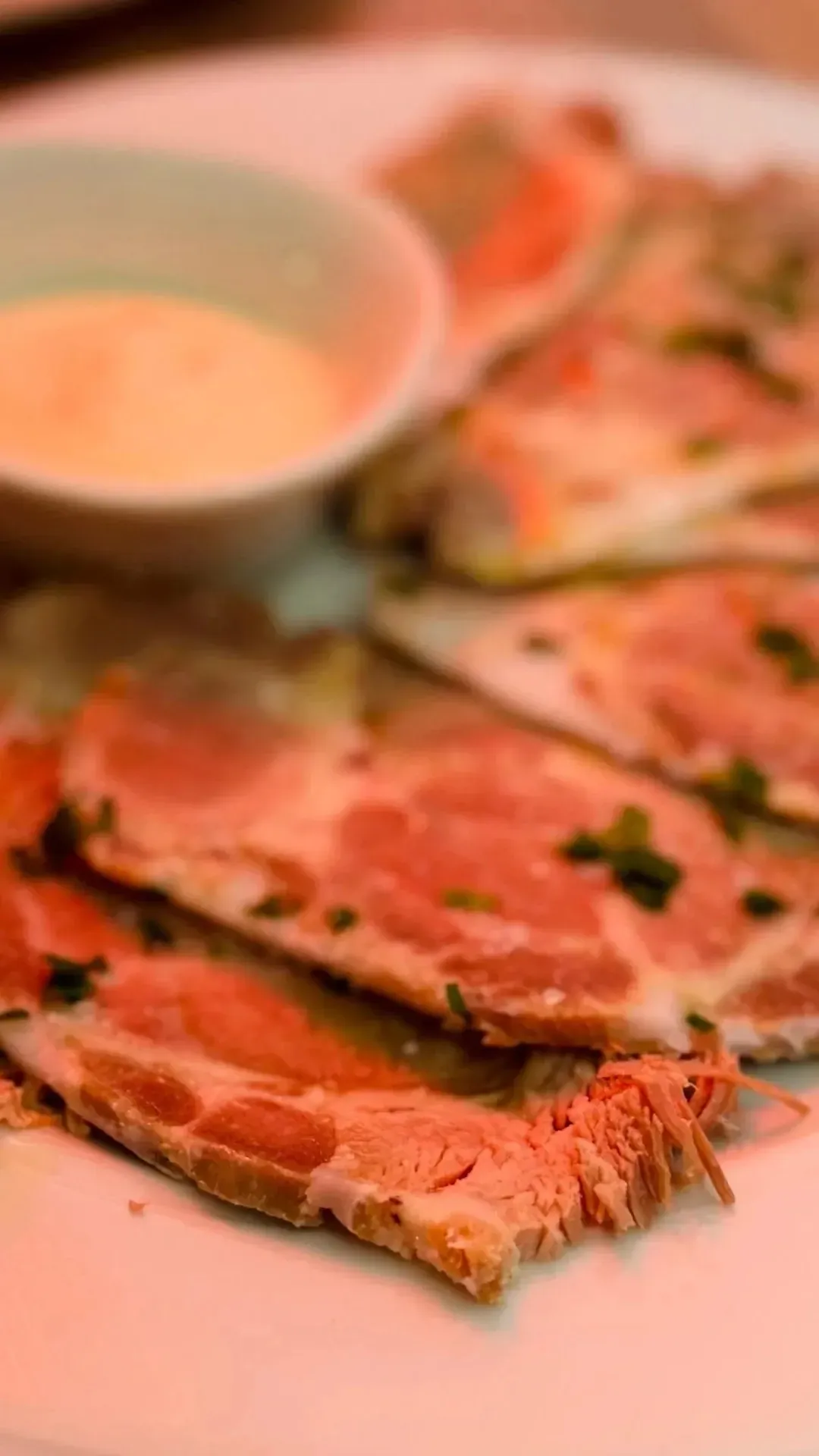 Un primer plano de un plato de comida con un tazón de salsa para mojar.