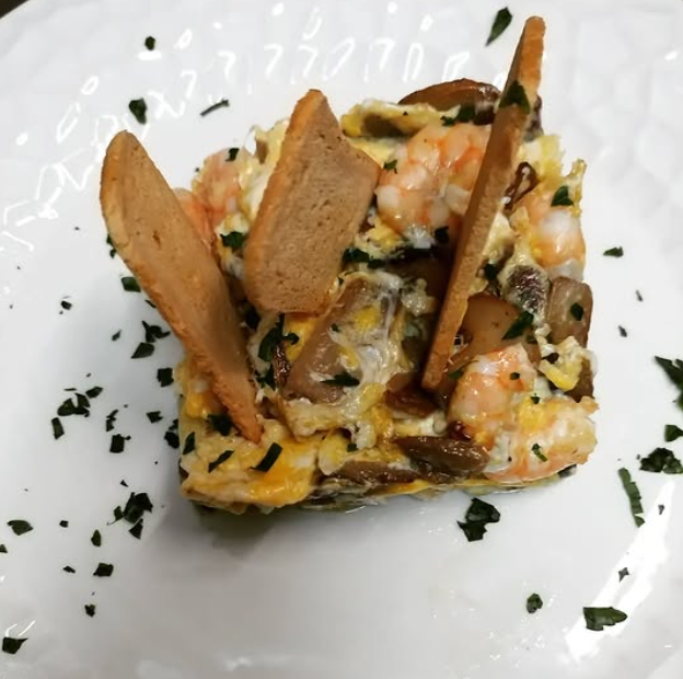 Un primer plano de un plato de comida con algunos trozos de pan encima.