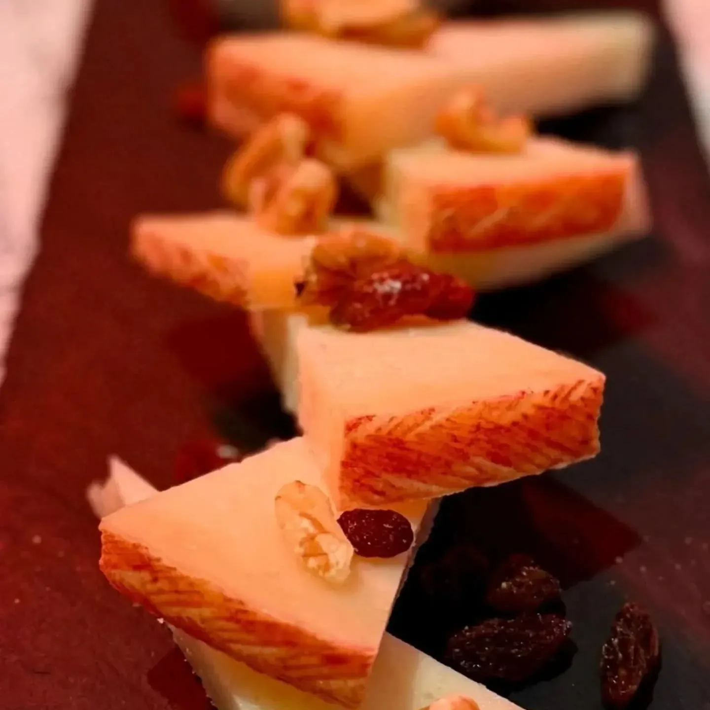 Rebanadas de queso con nueces y pasas en un plato