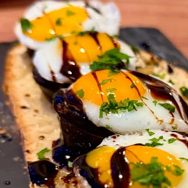 Un primer plano de un plato de comida con huevos y salsa.