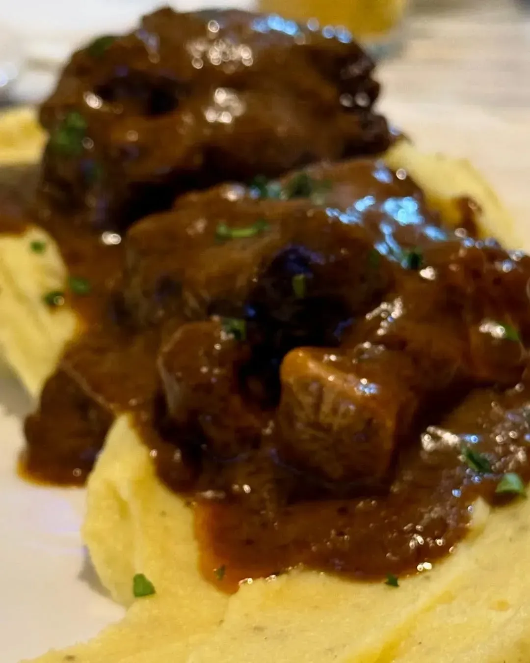 Un primer plano de un plato de comida con puré de papas y salsa.