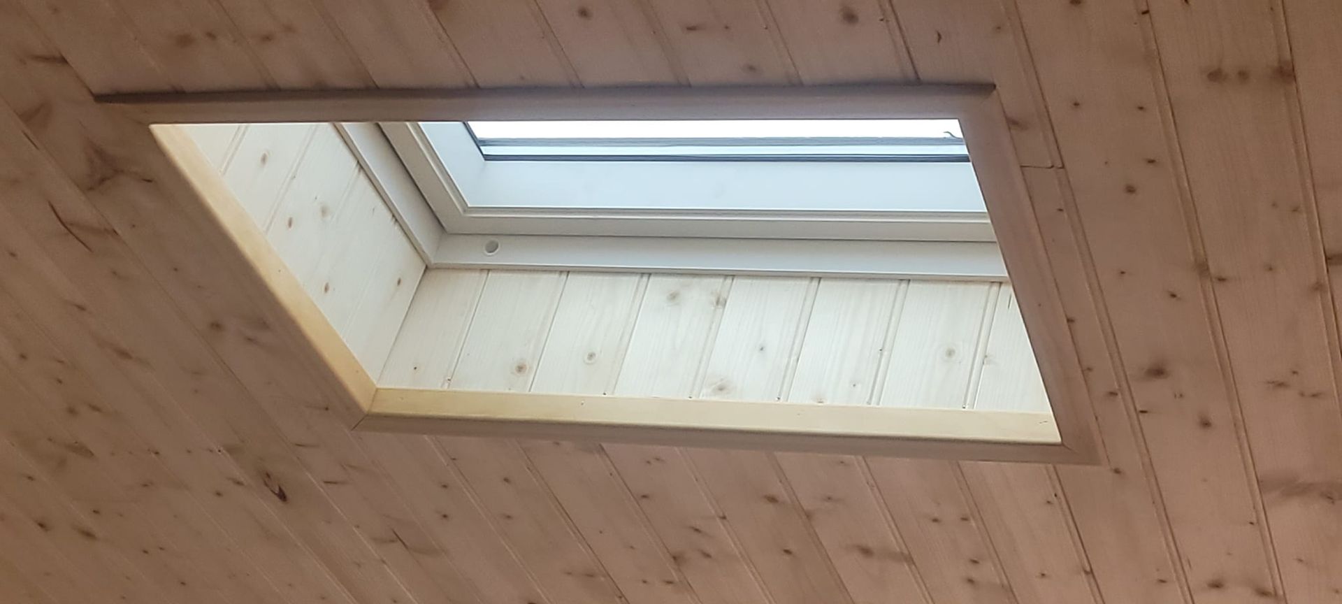 Habillage en bois autour d'une fenêtre de toit