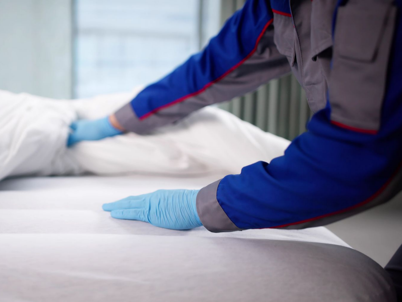 Une personne qui inspecte un lit.