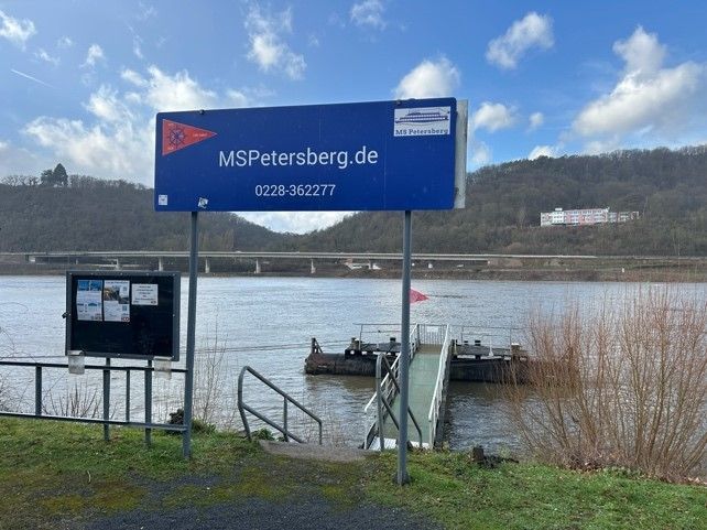 Vor einem Gewässer steht ein blaues Schild mit der Aufschrift mspetersberg.de.