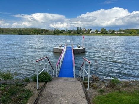 Ein blau-weißes Dock, das zu einem großen Gewässer führt.