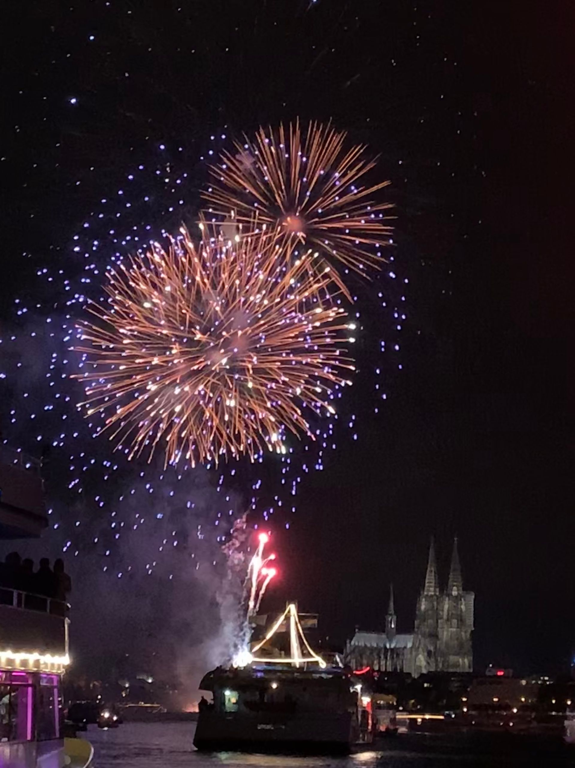Eine Gruppe von Menschen sitzt bei Sonnenuntergang auf einem Boot im Wasser.