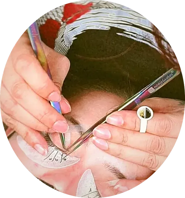 Una mujer se está depilando las pestañas con un par de pinzas.