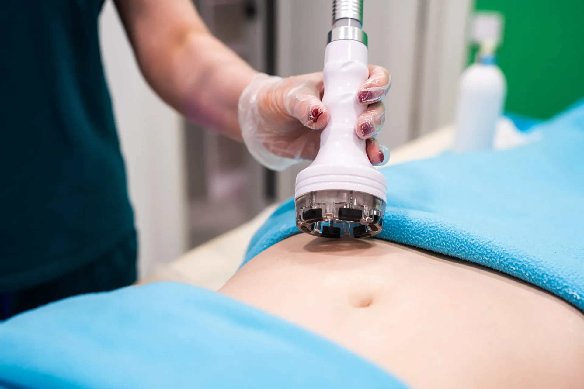 Sonda de ultrasonido examinando el abdomen de un paciente en un entorno clínico.